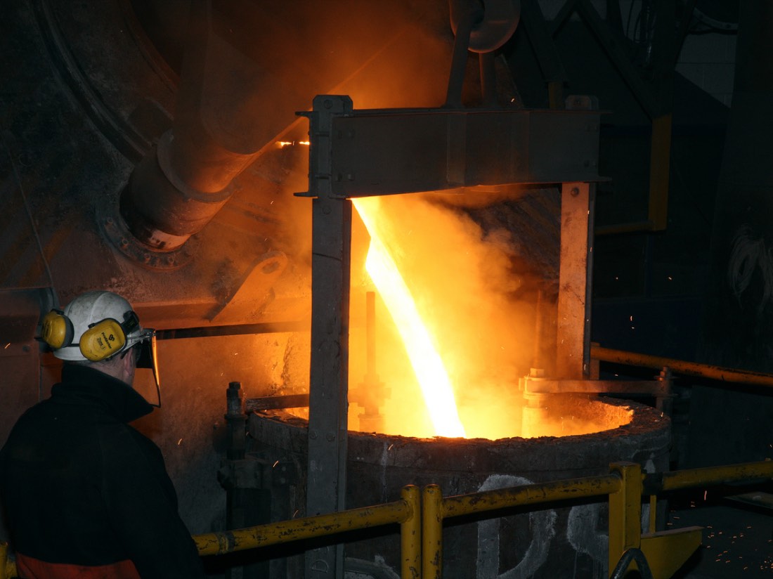 Molten metal being poured into a ladle at a steel mill